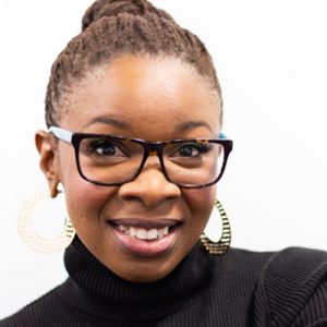 A smiling black woman with glasses and pulled-back hair looking at the camera